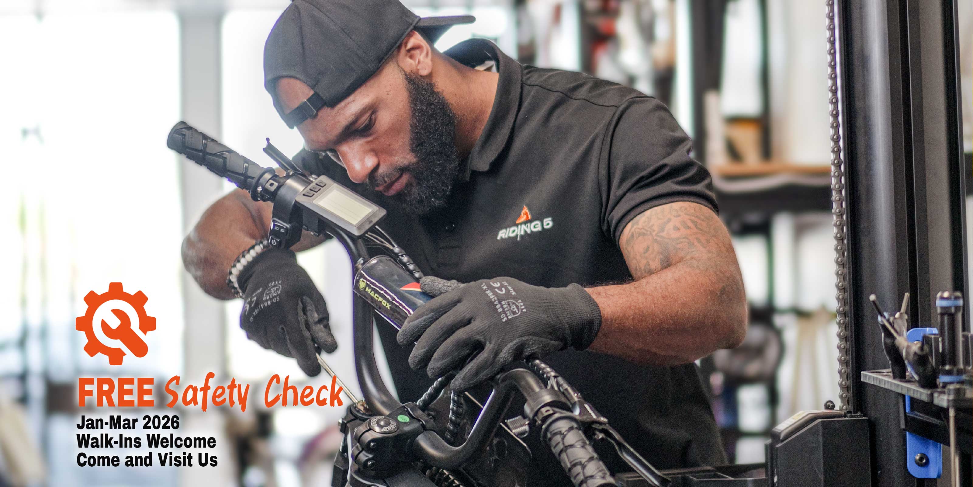 Riding 5 technician performing professional e-bike safety inspection and maintenance service