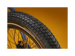Close up of an ebike tire tread pattern against a gold background.