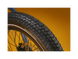 Close up of an ebike tire tread pattern against a gold background.